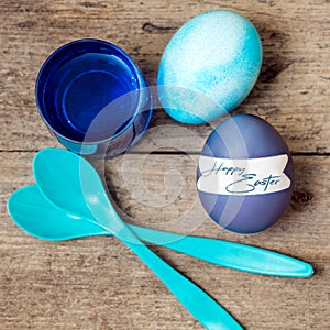 Blue greeting card with easter eggs, egg spoons and egg dyes, te