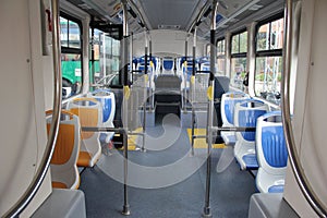 Blue and grey seats for passengers in saloon of empty city bus