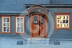 Blue grey wooden house facade with brown open door