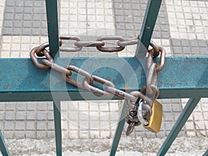 Blue grille with used and dirty padlock and chain