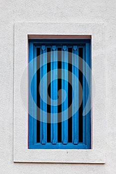 Blue grille wood window and white cement wall