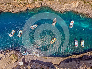 Blue Grotto in Malta. Pleasure boat with tourists runs. Aerial top view