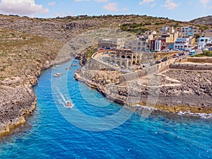 Blue Grotto in Malta. Pleasure boat with tourists runs. Aerial top view