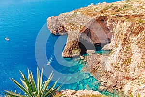 Blue Grotto in Malta. Pleasure boat with tourists runs. Natural arch window in rock