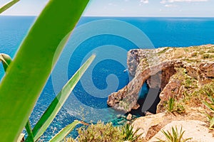 Blue Grotto in Malta. Pleasure boat with tourists runs. Natural arch window in rock