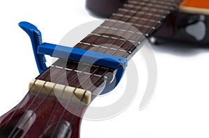 Blue guitar capo and guitar isolated on white background