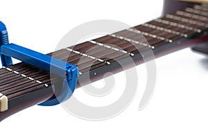 Blue guitar capo and guitar isolated on white background