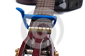Blue guitar capo and guitar isolated on white background