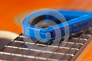Blue guitar capo and guitar isolated on white background