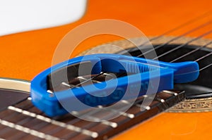 Blue guitar capo and guitar  on white background