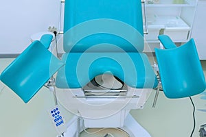 Blue gynecological chair in medical office in clinic.