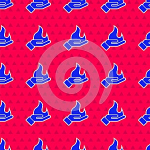 Blue Hand holding a fire icon isolated seamless pattern on red background. Vector