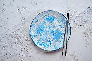 Blue hand painted ceramic serving plate with wooden chopsticks on side