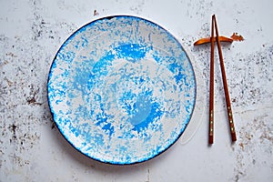 Blue hand painted ceramic serving plate with wooden chopsticks on side