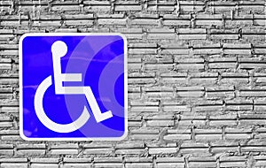 Blue handicap parking or wheelchair on wall brick .