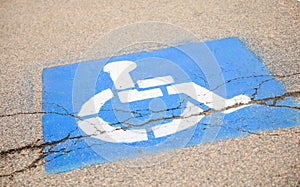 Blue handicap sign on the street - a symbol for mobility aid for people with disabilities