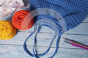 Blue Handmade Knitting Bag on Wood Table with Yarn Ball and Knitting Needles.