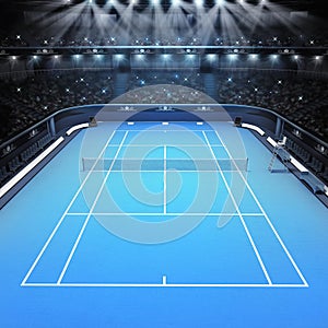 Blue hard surface tennis court and stadium full of spectators with spotlights