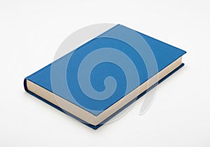 Blue hardcover book resting on a white surface. The book has a plain cover with a m