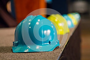Blue Hardhat on Lined Background with Yellow and Blue hats blurred
