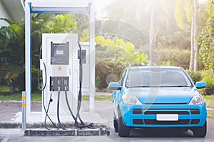 A blue hatchback car at a car charging station. Hydrogen fuel and hydrogen car