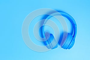 Blue headphones, Top view of headphones on blue background. Minimalist photo of earphones with copy space. White dj headphones,