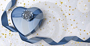 Blue heart gift box with curl ribbon on white background.