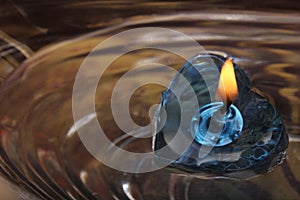 Blue heart shaped candle floating on water, festival concept