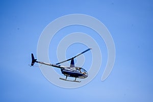 Blue Helicopter Crosses Sky photo