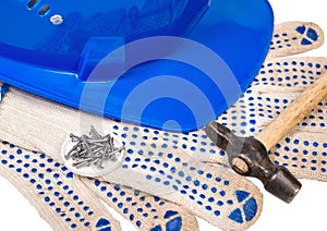 Blue helmet gloves hammer and nails  on white background