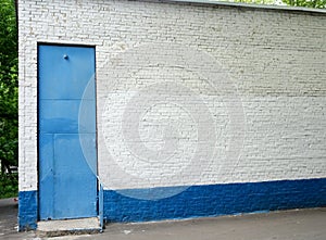 Blue high door in the white brick wall, copy spase