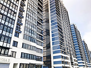 Blue high modern monolithic frame building, house, new building, a skyscraper with mirrored windows against a blue sky. Concept: