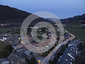 blue hour aerial image of a quiet residential area in a village with single family houses and mountains in the background