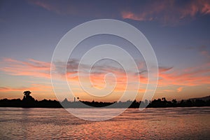 Blue hour over a river with the far bank in silhouette