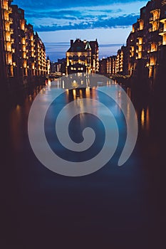 Blue hour in Warehouse District - Speicherstadt. Tourism landmark of Hamburg in twilight. View of Wandrahmsfleet in