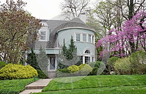 Blue House with Large Round Turret and Spring Foliage