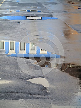 Blue house reflected in puddles topview image