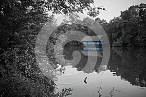 Blue house with straw roof on the lake