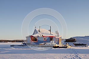 Blue houseboat on Yellowknife Bay in Great Slave Lake at sunset