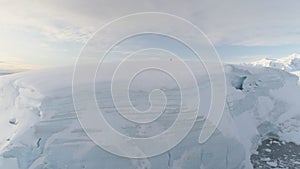 Blue ice cave in white glacier on Antarctic Peninsula. Aerial shot close-up.