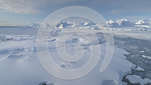 Blue ice cave in white glacier on Antarctic Peninsula. Aerial shot close-up.