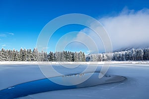 Blue ice and cracks on the surface of the ice. Frozen lake under a blue sky in the winter