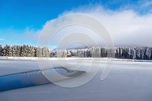 Blue ice and cracks on the surface of the ice. Frozen lake under a blue sky in the winter