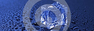 Blue ice cube with water drops. Panoramic image