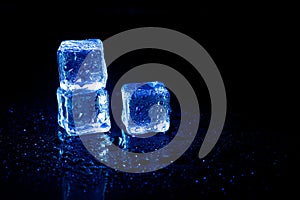 Blue ice cubes reflection on black table background