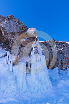 Blue ice waterfall on Ogoy Island in the Maloye More Strait on Lake Baikal on a sunny winter day. Siberia, Russia