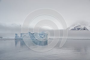 Blue iceberg in cloudy weather