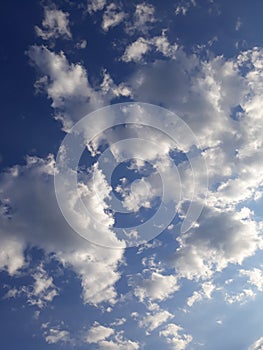 Blue illuminated cloudy radiant sunny sky with fluffy clouds