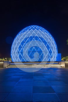 Blue illuminated sphere dome located next to Sheikh Zayed Grand Mosque in Abu Dhabi UAE, shot at night.