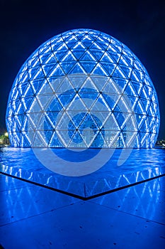 Blue illuminated sphere dome located next to Sheikh Zayed Grand Mosque in Abu Dhabi UAE, shot at night.